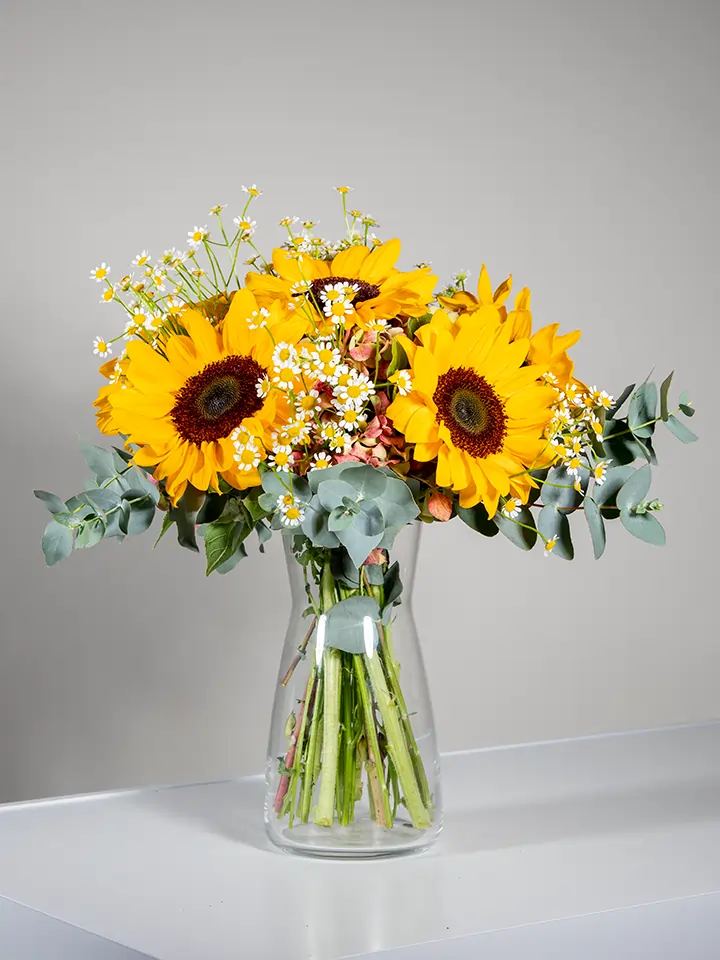 Bouquet di girasoli e camomilla in vaso di vetro